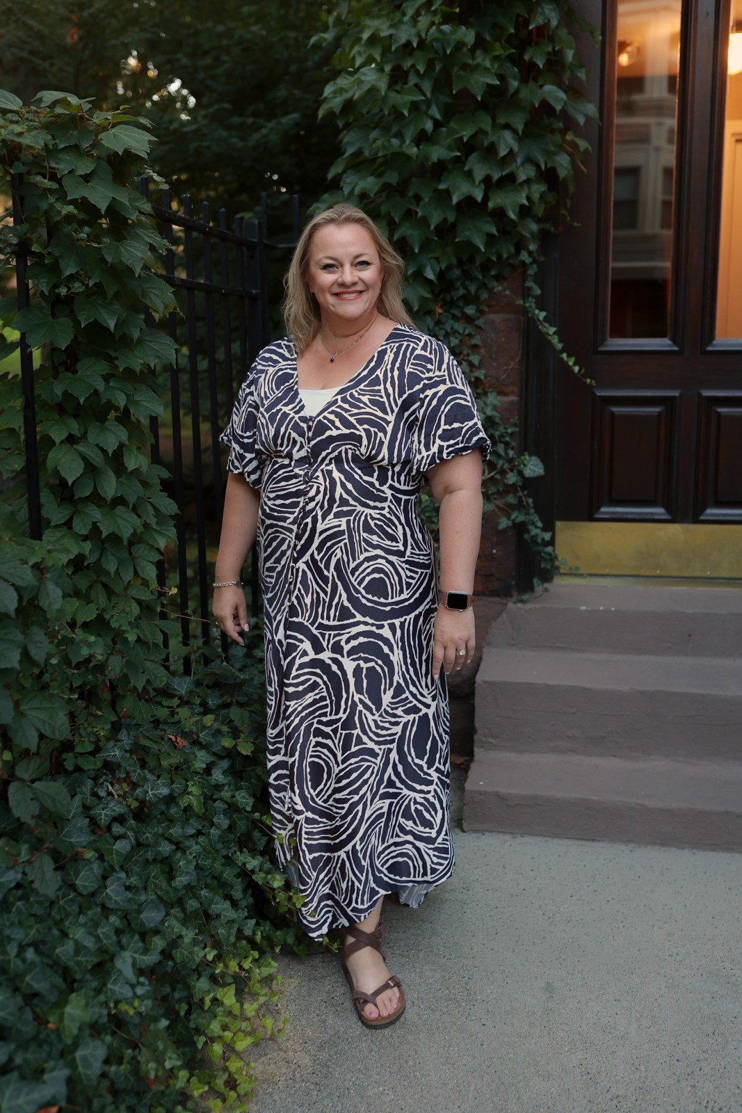 Kris Porter, travel advisor, standing by a brownstone doorway
